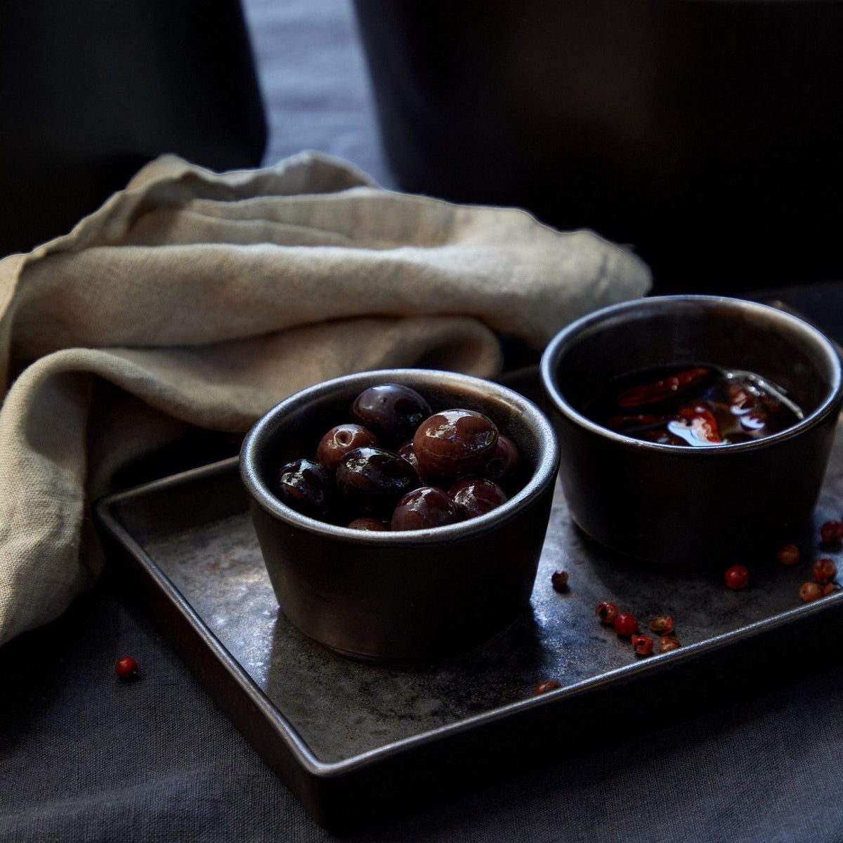 SC Hospitality Lagoa 7cm stoneware ramekins in metallic charcoal glaze holding olives on a dark rectangular tray