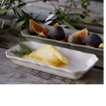 SC Hospitality Alentejo white rectangular ceramic tray holding sliced cheese on a rustic wooden table with figs