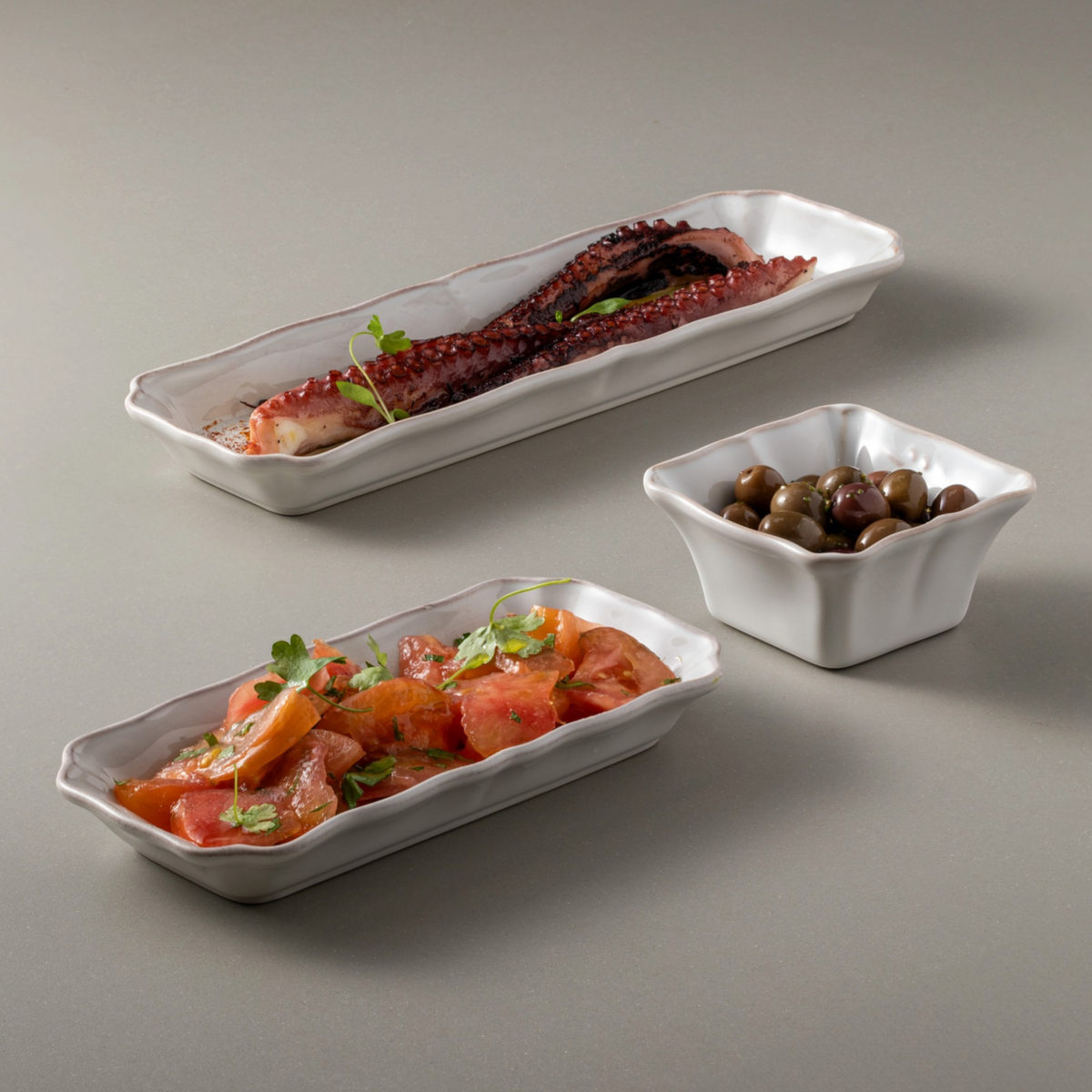 SC Hospitality white rectangular Alentejo ceramic tray holding grilled octopus and tomato salad on a grey background