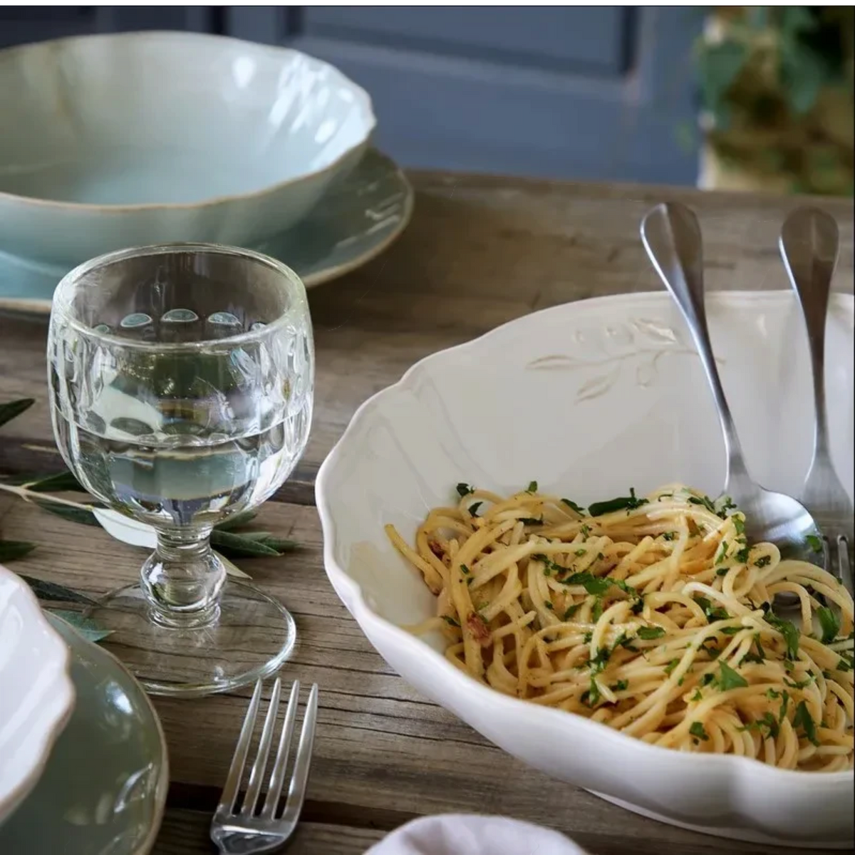 SC Hospitality Alentejo white ceramic serving bowl with scalloped edges filled with pasta on a rustic wooden table