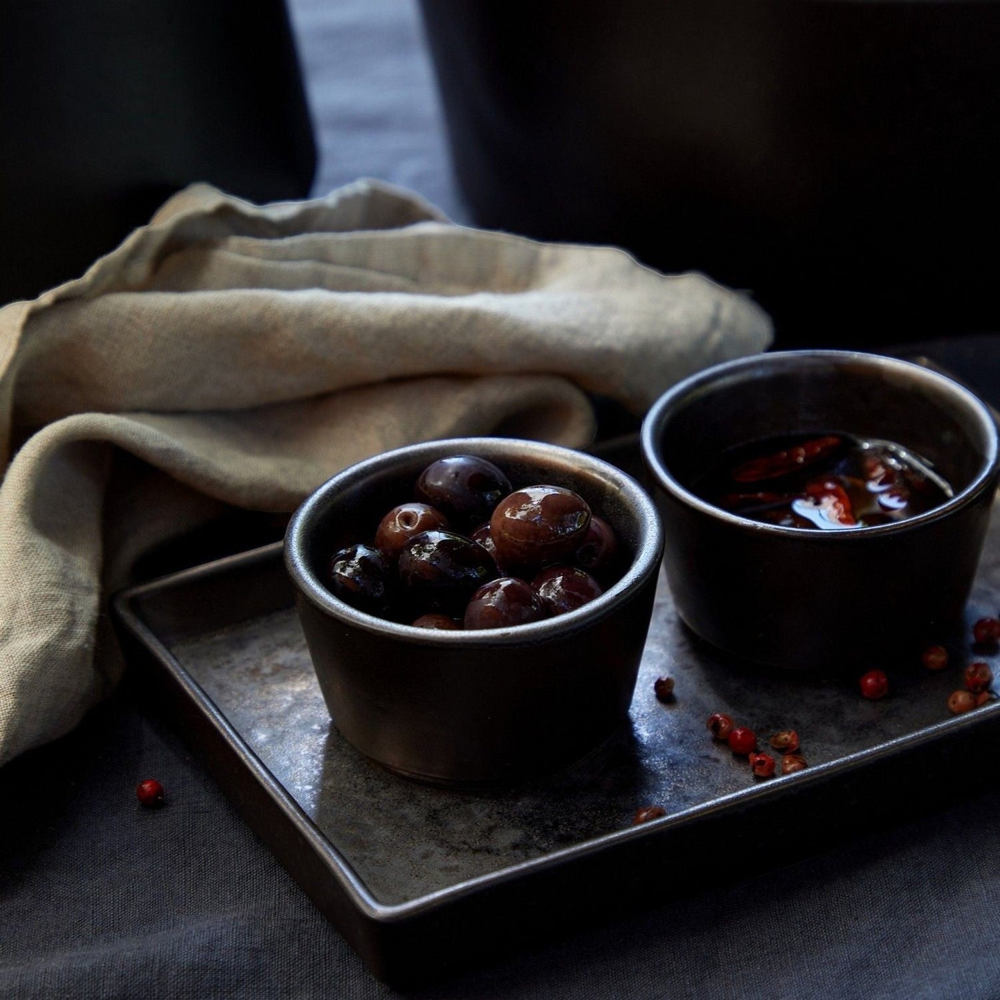 SC Hospitality Lagoa 7cm stoneware ramekins in metallic charcoal glaze holding olives on a dark rectangular tray