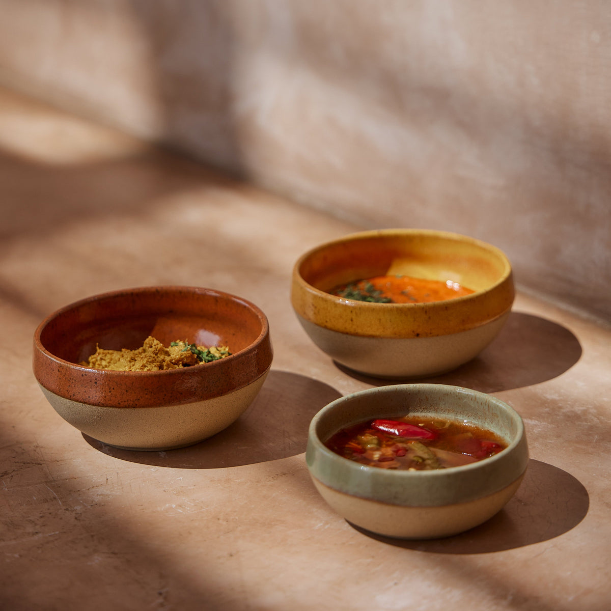 SC Hospitality Marrakesh stoneware dip bowls in eucalyptus, orange, and yellow with hand-stamped textured rims.