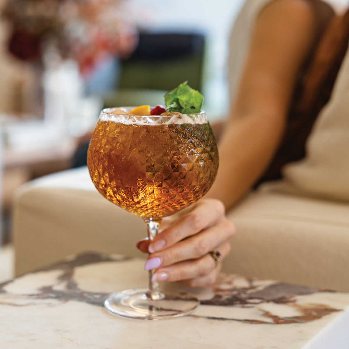 SC Hospitality Zafferano Mixology balloon goblet filled with amber cocktail and garnished with mint and citrus