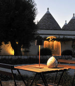 SC Hospitality Olivia Pro cordless table lamp in corten finish on an outdoor terrace at dusk