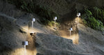 SC Hospitality Olivia Pro white cordless LED table lamps illuminating a rocky outdoor cave wall at night
