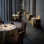 SC Hospitality Pina cordless table lamp in corten finish on a restaurant dining table in a stone colonnade setting