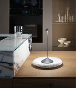 SC Hospitality Pina cordless dark grey table lamp with a sleek minimalist design on a textured white plate
