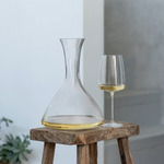 SC Hospitality Sensa 750ml crystal glass wine decanter with a slender neck and matching wine glass on a wooden stool.