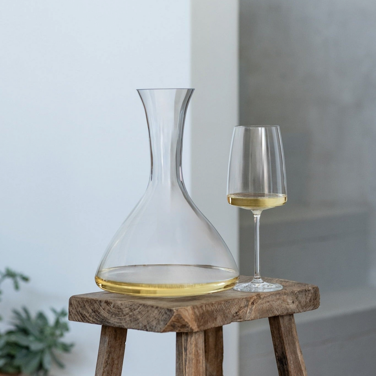 SC Hospitality Sensa 750ml crystal glass wine decanter with a slender neck and matching wine glass on a wooden stool.