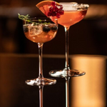 SC Hospitality Tone small cocktail coupe glasses filled with vibrant cocktails, garnished with fruit and herbs.