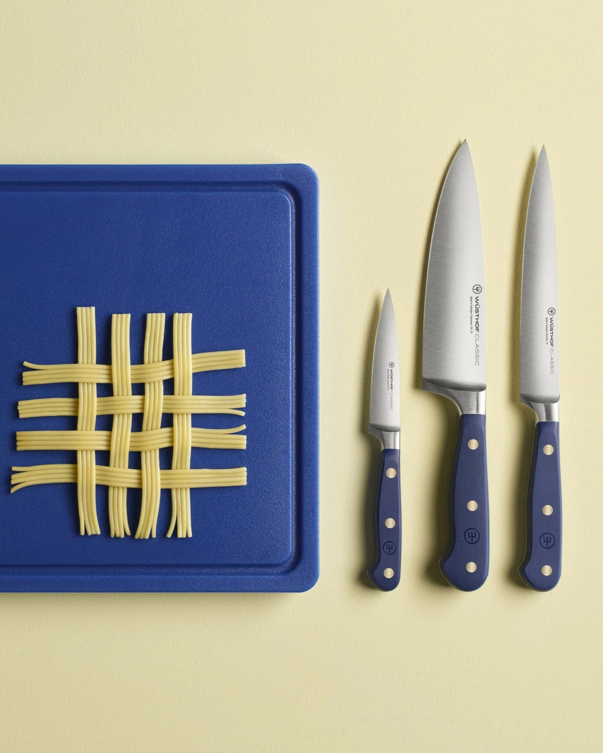 SC Hospitality Wüsthof Wild Blueberry paring and chef knives with blue handles next to a blue cutting board