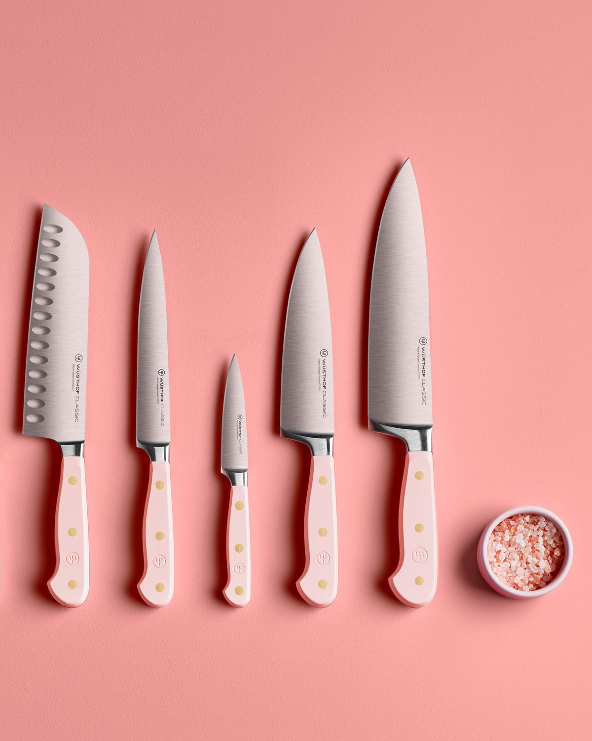 SC Hospitality WÜSTHOF Classic knife set with pink Himalayan salt handles and stainless steel blades on pink background