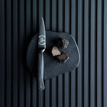 SC Hospitality WÜSTHOF Performer 9cm paring knife with black DLC coating and hexagon grip next to sliced truffles.