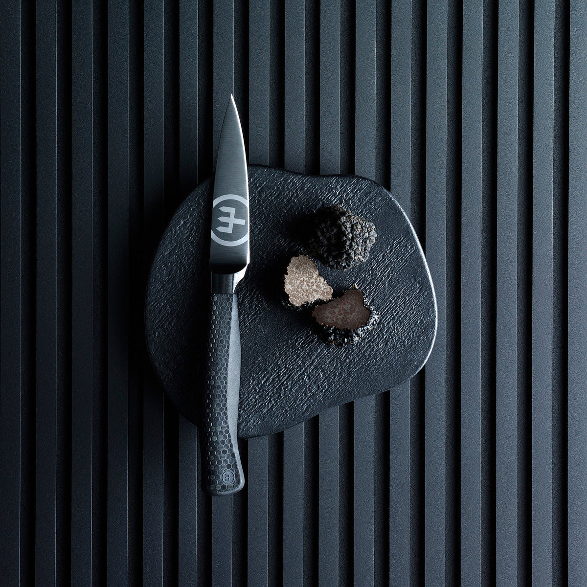 SC Hospitality WÜSTHOF Performer 9cm paring knife with black DLC coating and hexagon grip next to sliced truffles.