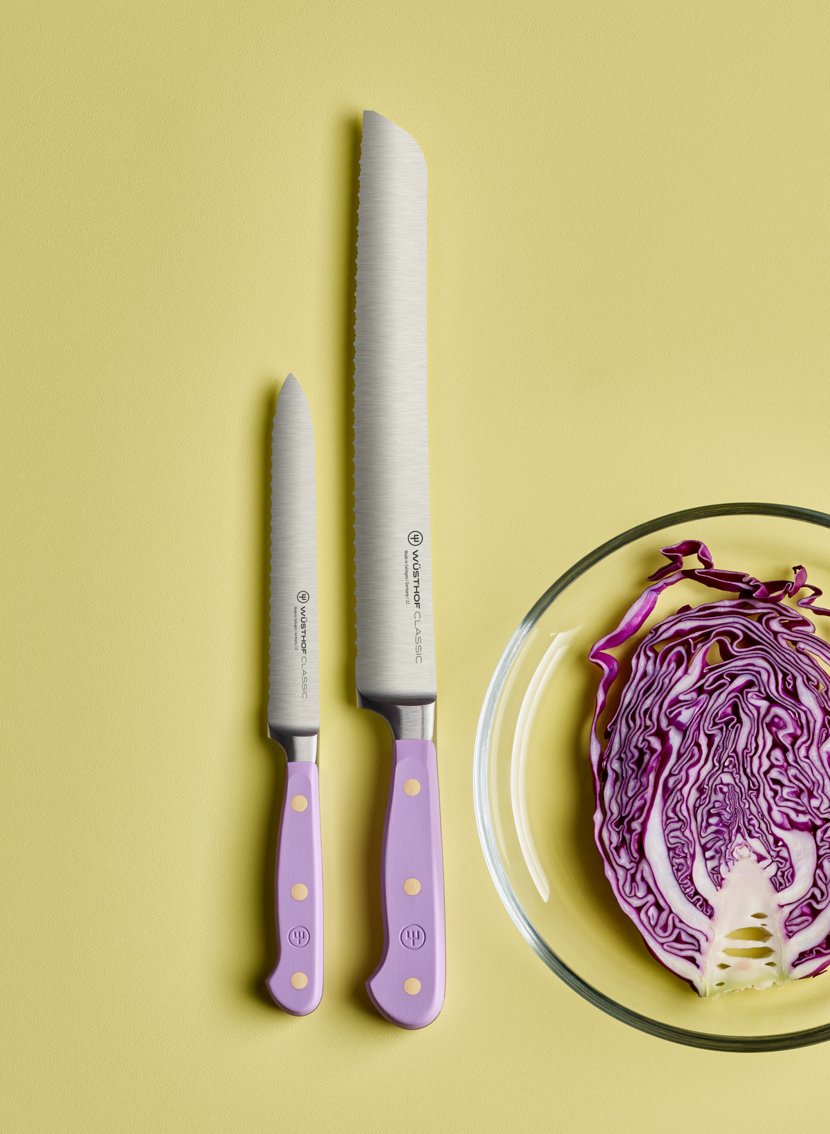 SC Hospitality Wüsthof Purple Yam serrated bread knife and utility knife set with ergonomic handles on yellow background