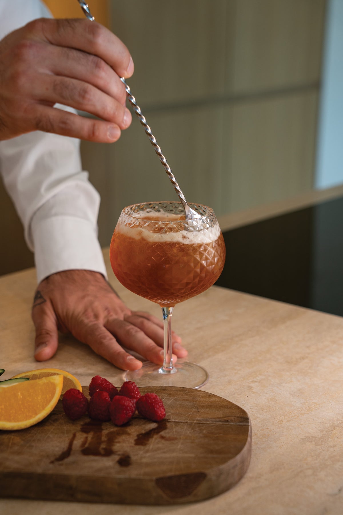SC Hospitality Zafferano Mixology balloon goblet with geometric texture being stirred with a cocktail spoon